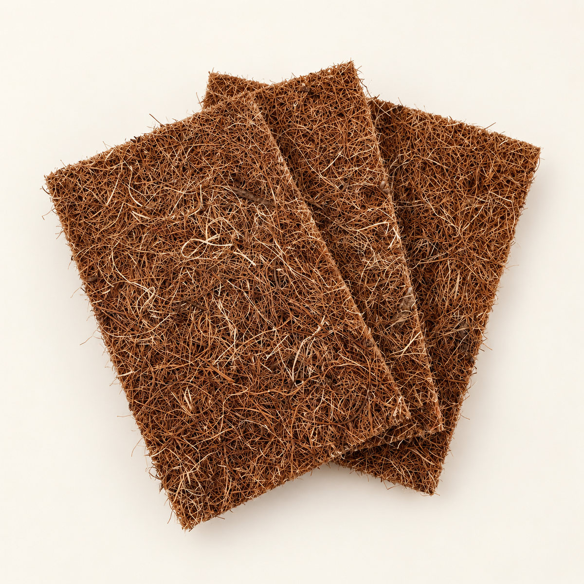 Trois tapis CocoMat rectangulaires en fibre de coco, disposés en éventail sur fond clair.