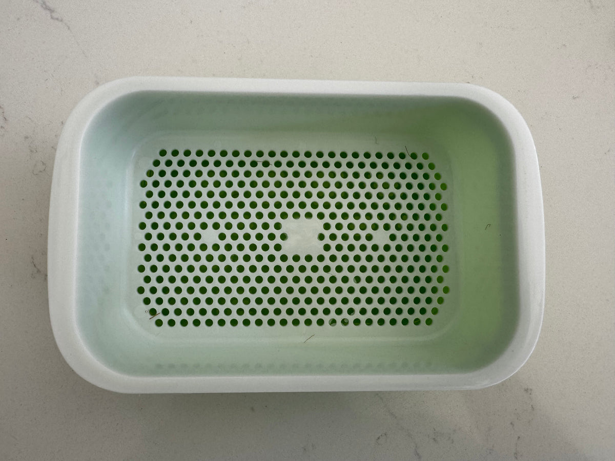 Bac de culture vert avec sa grille blanche perforée installée, vu de dessus.