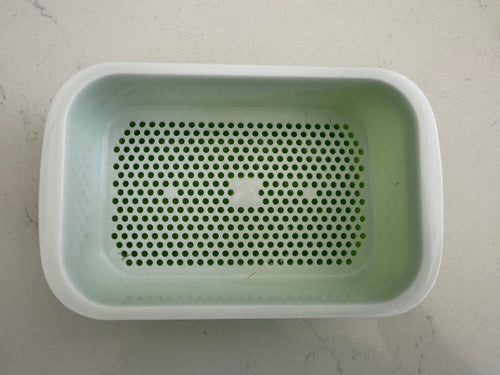 Bac de culture vert avec sa grille blanche perforée installée, vu de dessus.